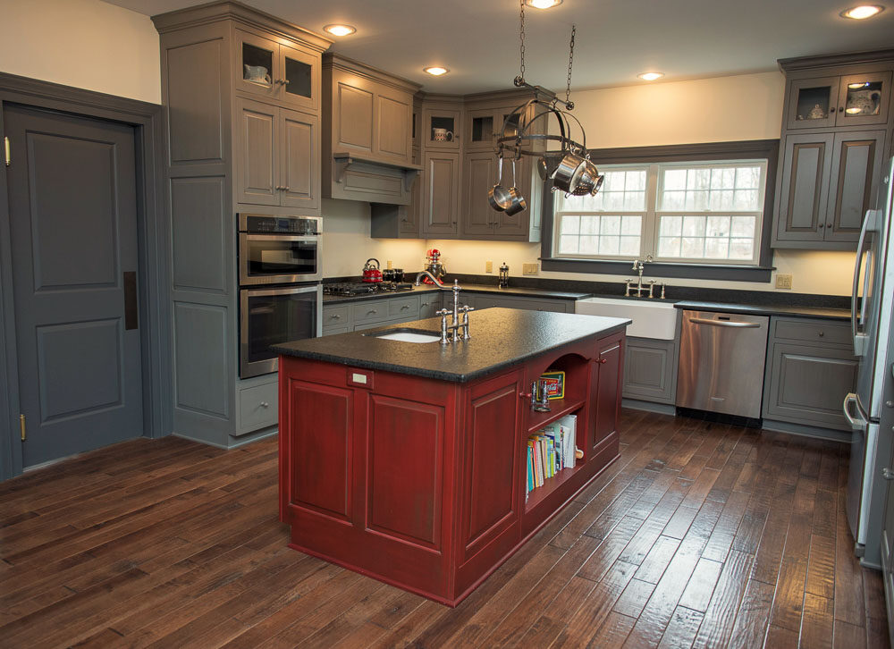 Custom kitchen with a red island, gray cabinetry, and wood floors